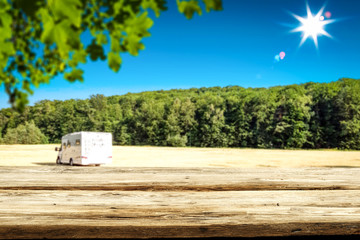 Table background and wooden board and  some trees in distance on sunny day