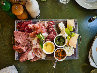 Cutting board based in charcuterie with jam variaties, antipasto, cheese  and sauces.