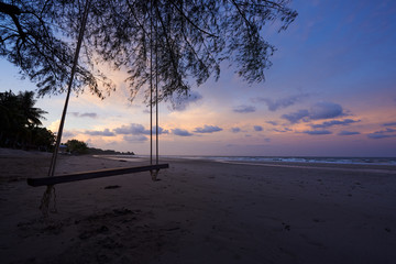 A wooden swing on the beautiful morning sky and sea background