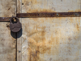 rusty lock hanging on old iron gate