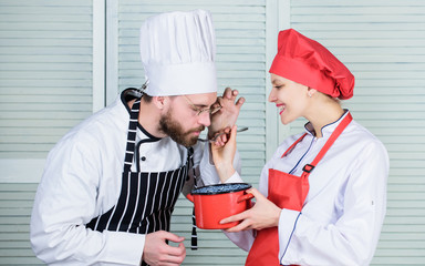 Woman and bearded man cooking together. Try ingredients before cook. Estimate taste. Healthy food....