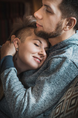 Happy couple in wooden ethnic chalet interior. Winter vacation