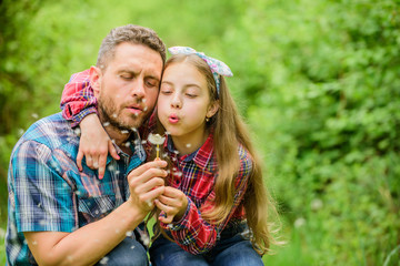 Happy family vacation. Father and little girl enjoy summertime. Dad and daughter blowing dandelion...