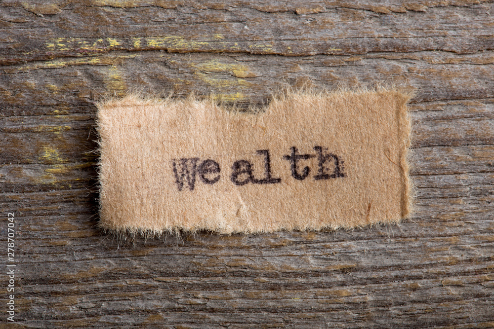 Fototapete wealth text printed with typescript, on wooden background