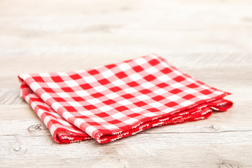  Red crumpled checkered tablecloth on a wooden table
