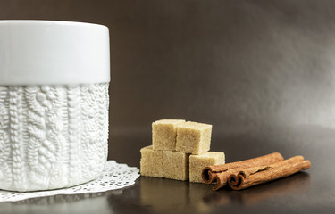 white mug with coffee on a dark background with sugar