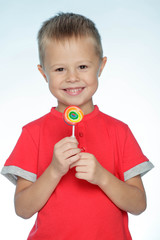 A child with candy. A little boy is holding candy in his hands. 