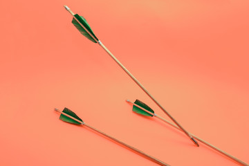 Old three green wooden arrow on a beautiful peach background.