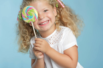 A little girl is holding candy in her hands. 