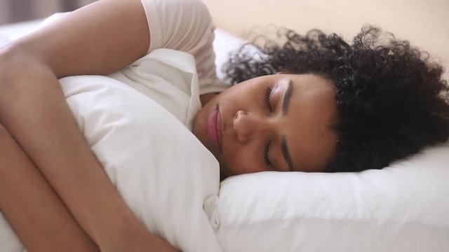 Depressed upset african woman feeling sad lying in bed alone