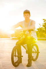 Rider sitting on bmx bike at sunset horizontal