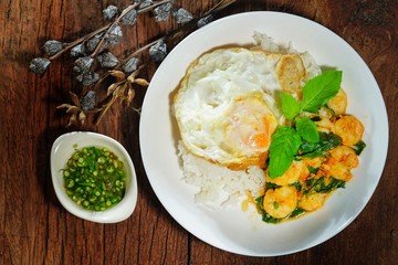 Thai food : Kaphrao Kung is Stirred and fried shrimps with holy basil and chilies served on steamed rice and fried egg. Shooting in studio for advertising. Thai and Asian food concept.