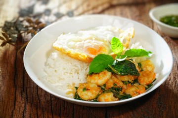 Thai food : Kaphrao Kung is Stirred and fried shrimps with holy basil and chilies served on steamed rice and fried egg. Shooting in studio for advertising. Thai and Asian food concept.