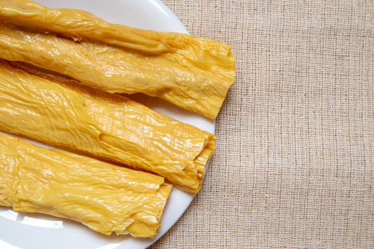 Dried yuba sticks or Fuzhu or dried bean curd In a white dish on a light brown cloth