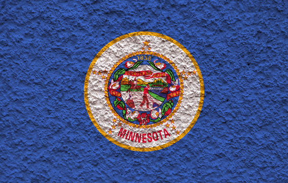 The national flag of the US state Minnesota in against a gray wall with stony surface on the day of independence in blue red and yellow. Political and religious disputes, customs and delivery.