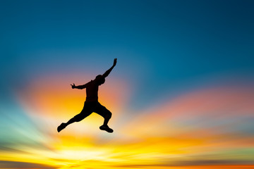 Happy man jumping At the time of the sun set Concept of vacation and travel