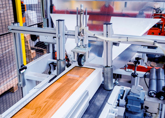 Production line of the wooden floor factory. CNC automatic woodworking machine.