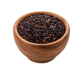 Black rice groats in wooden bowl isolated on white background