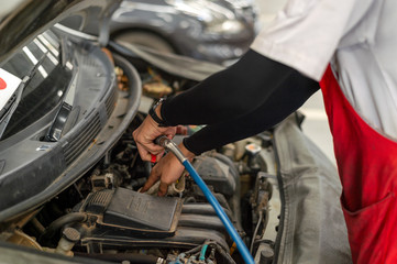 mechanic working car maintenance with soft-focus and over light in the background
