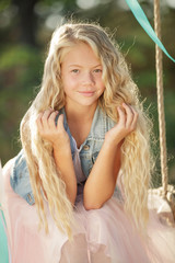 The child on a swing. Girl riding on a swing in the park. 