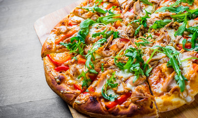 Pizza with Mozzarella cheese, salmon fish, tomato sauce, pepper. Italian pizza on wooden table background