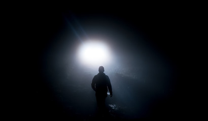 Silhouette of a man in front of a white light