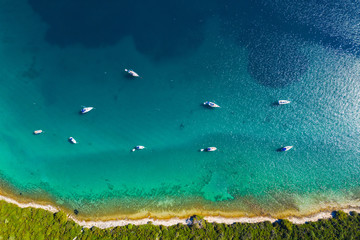 Aerial view of sailing boats in a beautiful turquoise lagoon on pine beach on Dugi Otok island, Croatia, beautiful seascape