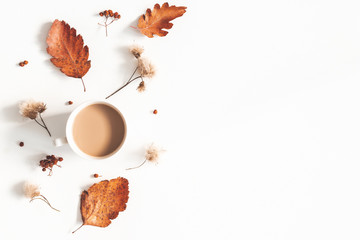 Autumn composition. Cup of coffee, autumn flowers, leaves on white background. Flat lay, top view, copy space