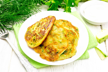 Pancakes of zucchini on wooden board