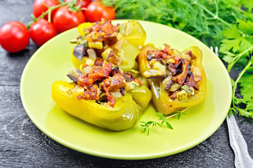 Pepper stuffed with vegetables in green plate on board