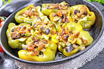 Pepper stuffed with vegetables in pan on black wooden board