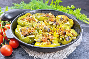 Pepper stuffed with vegetables in pan on wooden board