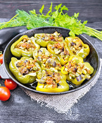 Pepper stuffed with vegetables in pan on dark board