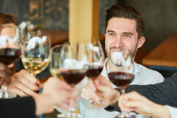 Young man toasting with a glass of wine