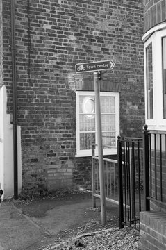  Black and white photo with the sign 'City Center' on the background of a brick house