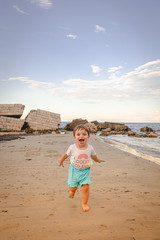 Bambina corre in riva al mare