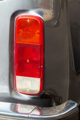Fototapeta premium Taillight of an old silver car minibus 