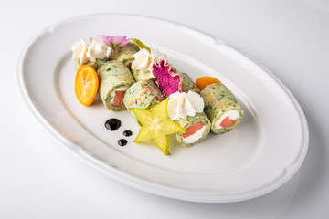 Pancakes rolls stuffed with salmon, spinach, Philadelphia cheese. Banquet festive dishes. Gourmet restaurant menu. White background.