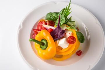 Snack from fresh vegetables and cheese. Tomatoes, cucumbers, peppers, onions. Banquet festive dishes. Gourmet restaurant menu. White background.