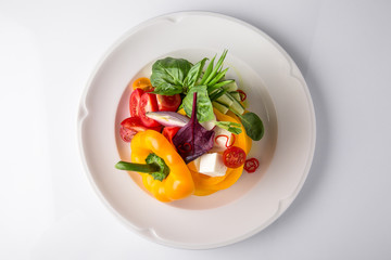 Snack from fresh vegetables and cheese. Tomatoes, cucumbers, peppers, onions. Banquet festive dishes. Gourmet restaurant menu. White background.
