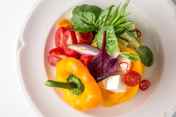 Snack from fresh vegetables and cheese. Tomatoes, cucumbers, peppers, onions. Banquet festive dishes. Gourmet restaurant menu. White background.
