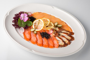 Snack from deli fish in the cutting. Salmon and white fish, perch and smoked eel. Banquet festive dishes. Gourmet restaurant menu. White background.