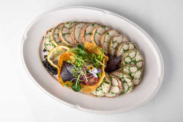 Roll of salmon and spinach. Delicate roll stuffed with fish, vegetables and herbs. Banquet festive dishes. Gourmet restaurant menu. White background.