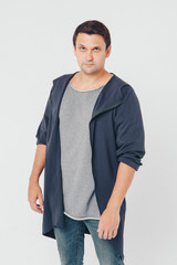 handsome man shows off gray clothes on white background