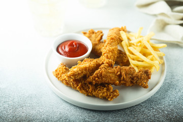 Homemade fish and chips on white plate