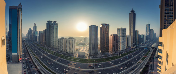 Skyscrapers and highways of a big modern city at sunset. Panoramic view on downtown Dubai, United Arab Emirates.