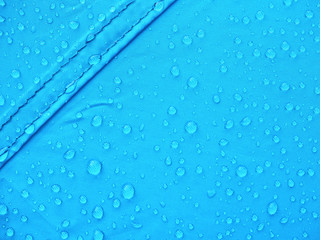 Blue rainproof tent sheet with morning rain drops