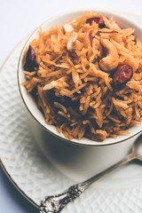 Traditional Jaggery Rice or Gur wale chawal in Hindi, served in a bowl with spoon. selective focus