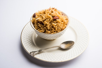 Traditional Jaggery Rice or Gur wale chawal in Hindi, served in a bowl with spoon. selective focus
