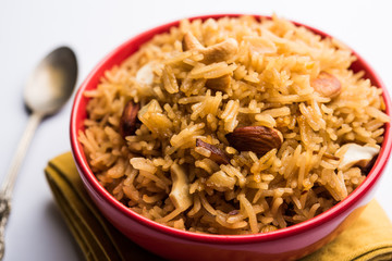 Traditional Jaggery Rice or Gur wale chawal in Hindi, served in a bowl with spoon. selective focus
